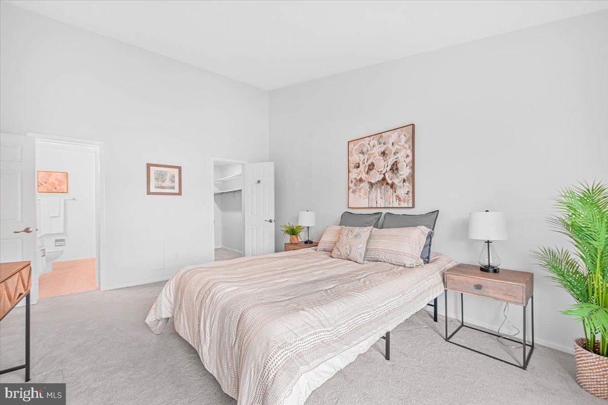 10717 Kings Riding Way, Unit 301 Rockville, MD 20852 - Photo 13 of 22 a bedroom with a bed and a painting on the wall