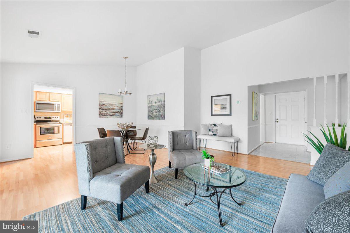 10717 Kings Riding Way, Unit 301 Rockville, MD 20852 - Photo 4 of 22 a living room with furniture and wooden floor