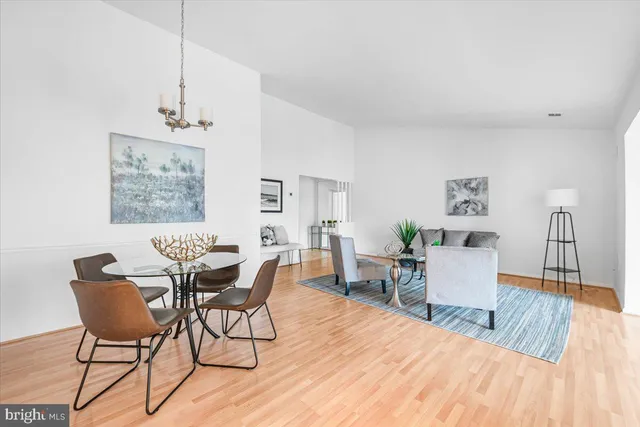 a dining room with wooden floor and a chandelier
