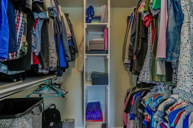 a view of walk in closet with clothes