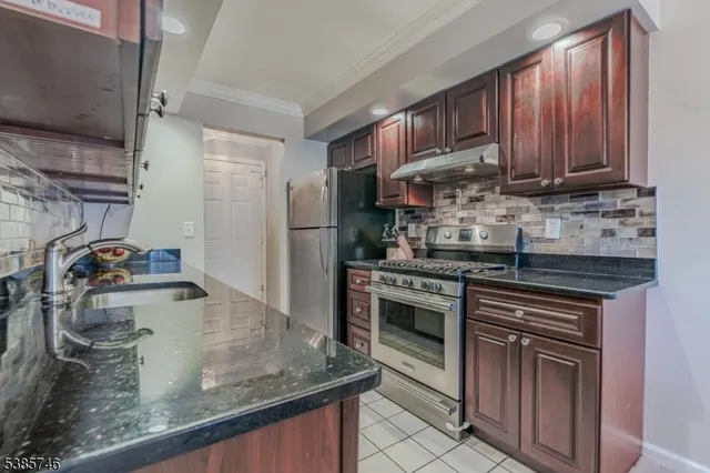 a kitchen with stainless steel appliances granite countertop a sink stove and refrigerator