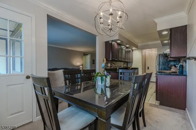 a view of a dining room with furniture a chandelier and wooden floor