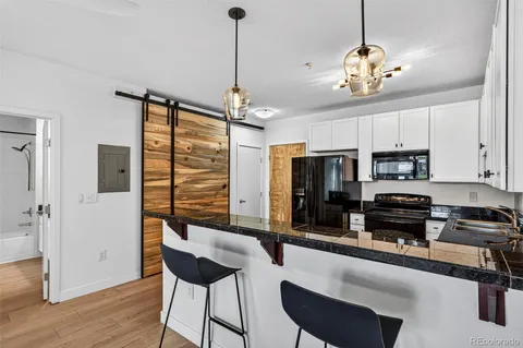 a kitchen with granite countertop a sink a stove and cabinets