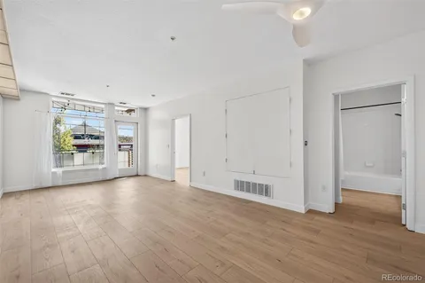 a kitchen with kitchen island granite countertop a refrigerator a stove a sink dishwasher a dining table and chairs with wooden floor