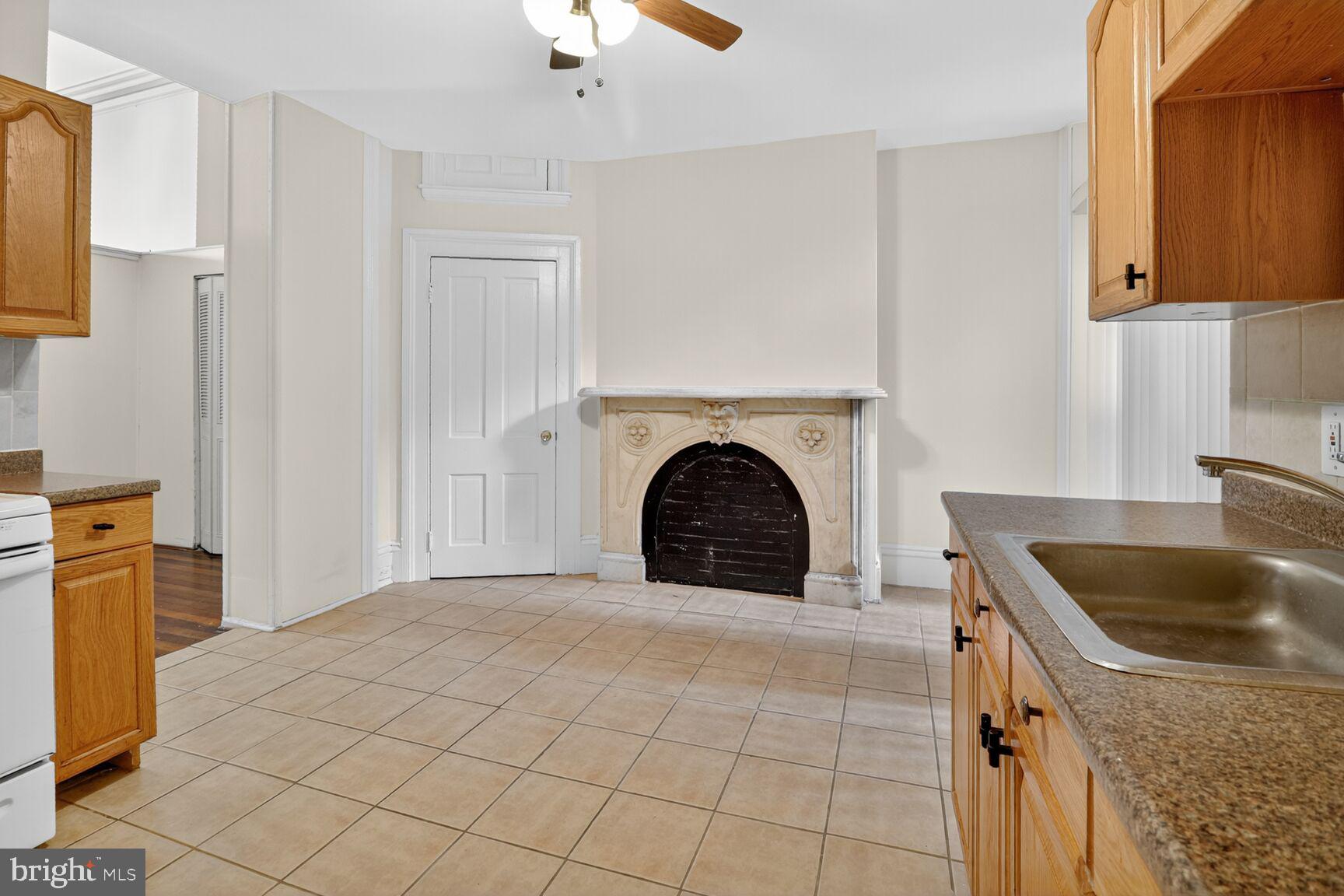 1404 Madison Avenue Baltimore, MD 21217 - Photo 11 of 54 a view of a kitchen with a sink dishwasher and a fireplace