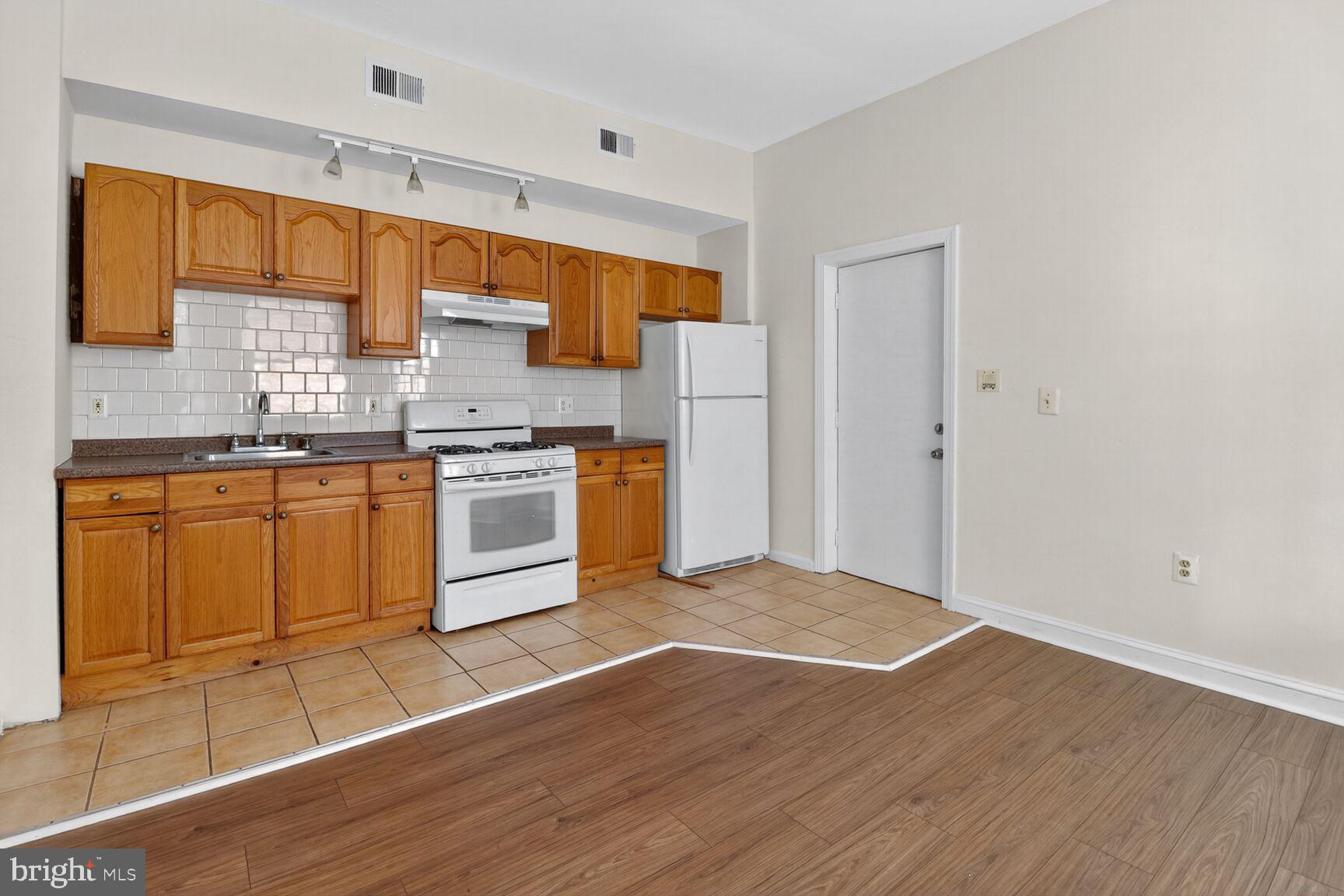 1404 Madison Avenue Baltimore, MD 21217 - Photo 18 of 54 a kitchen with stainless steel appliances granite countertop a stove a sink and a refrigerator