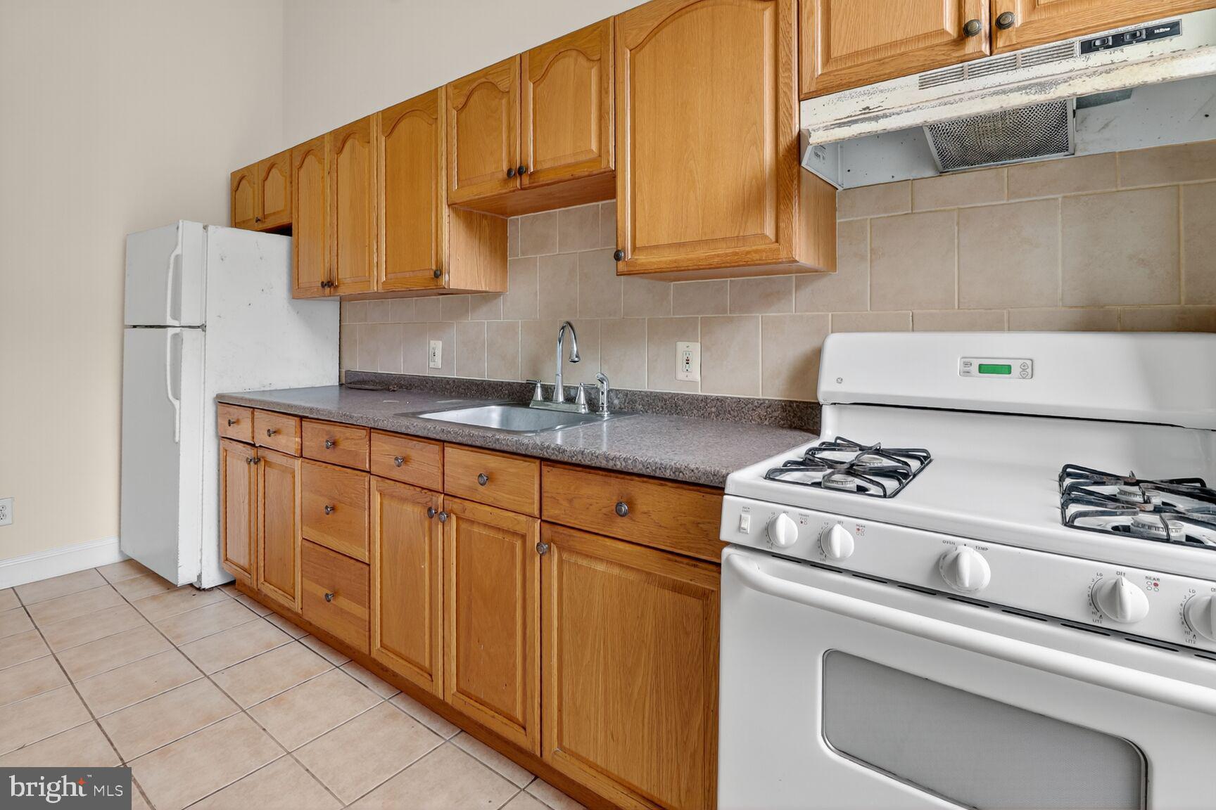 1404 Madison Avenue Baltimore, MD 21217 - Photo 29 of 54 a kitchen with stainless steel appliances granite countertop a sink stove and refrigerator