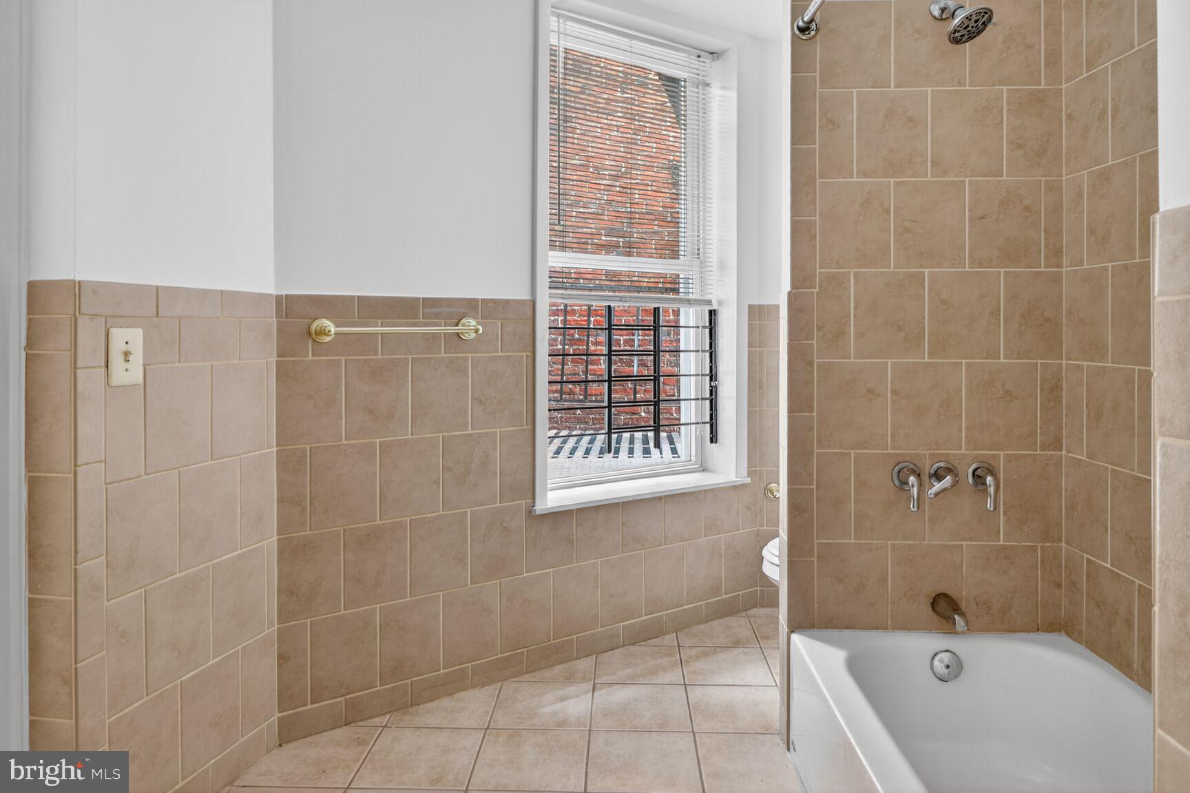 1404 Madison Avenue Baltimore, MD 21217 - Photo 31 of 54 a bathroom with a bathtub and shower