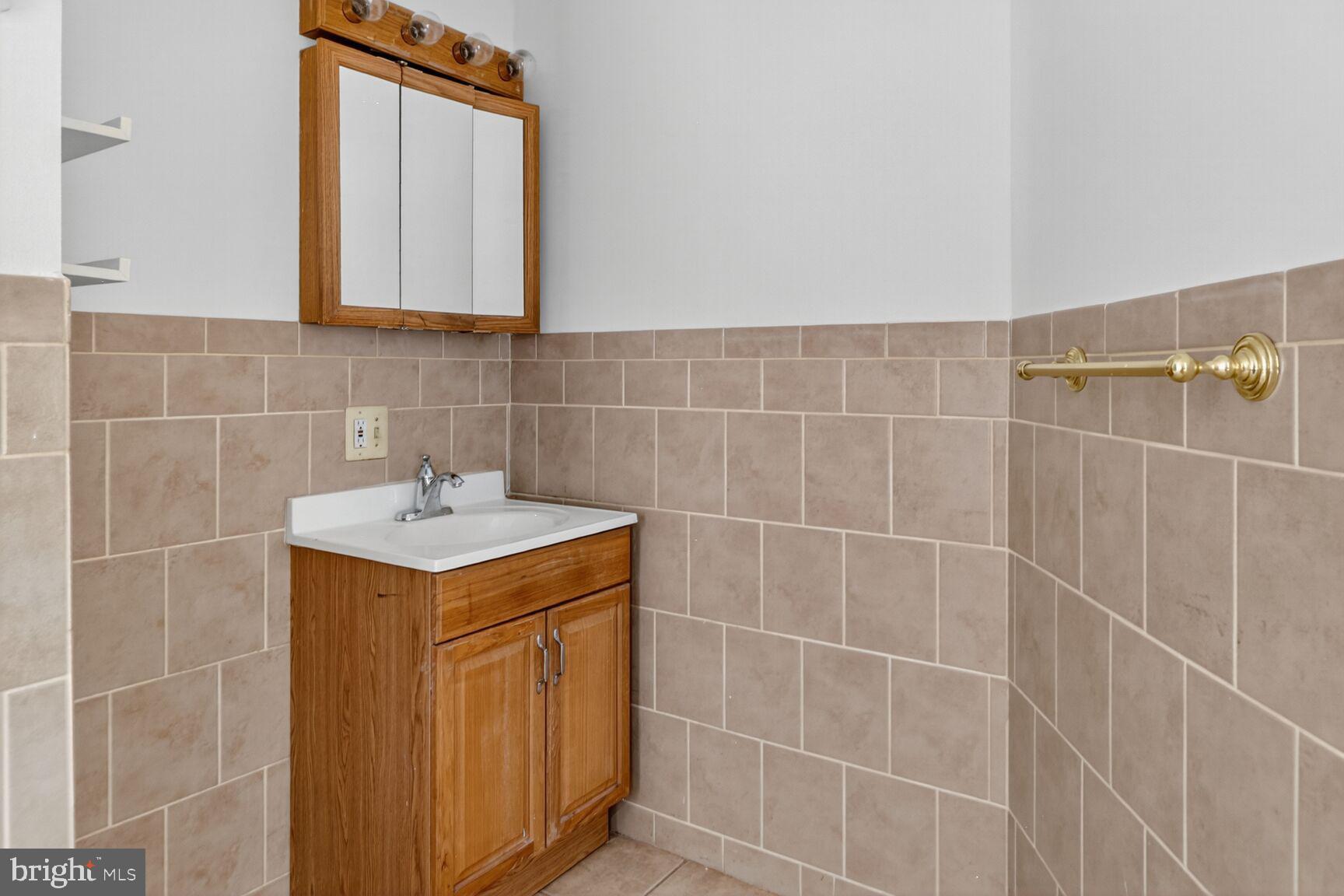 1404 Madison Avenue Baltimore, MD 21217 - Photo 32 of 54 a bathroom with a sink a mirror and vanity