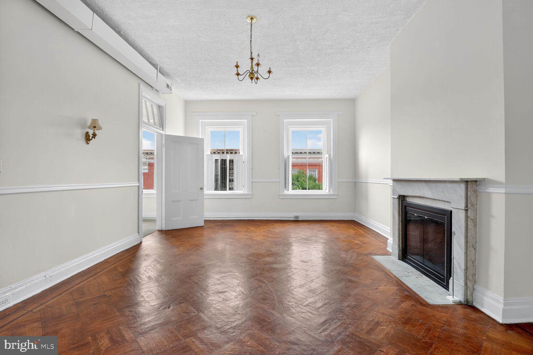 1404 Madison Avenue Baltimore, MD 21217 - Photo 33 of 54 a view of an empty room with chandelier and wooden floor