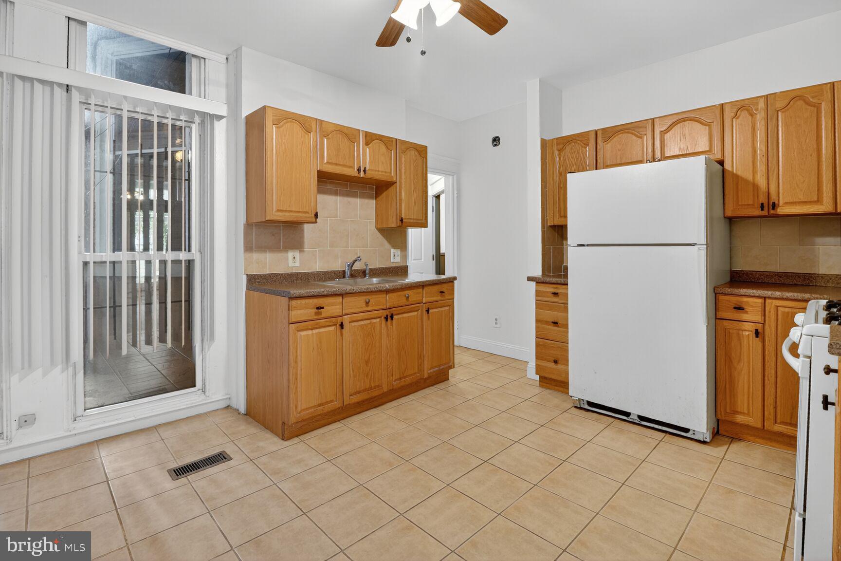 1404 Madison Avenue Baltimore, MD 21217 - Photo 37 of 54 a kitchen with a refrigerator a stove top oven and cabinets