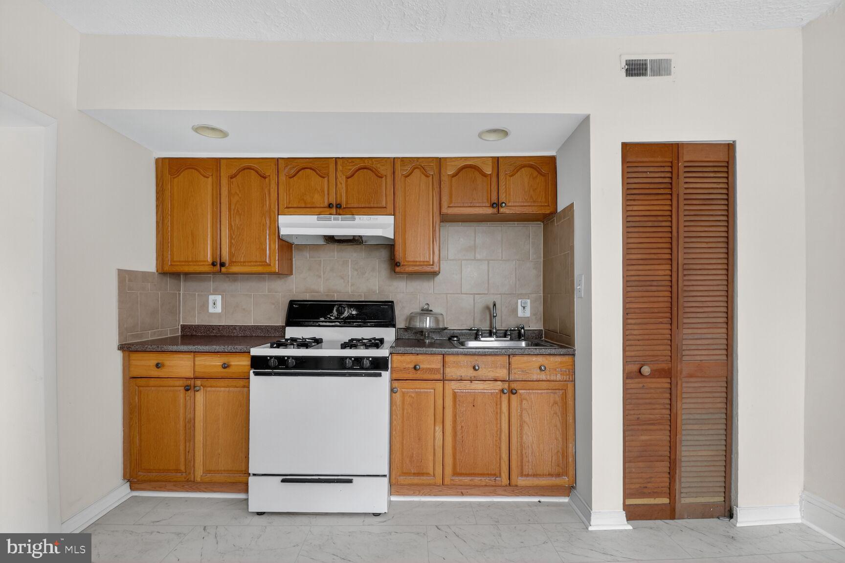 1404 Madison Avenue Baltimore, MD 21217 - Photo 38 of 54 a kitchen with a stove and a sink