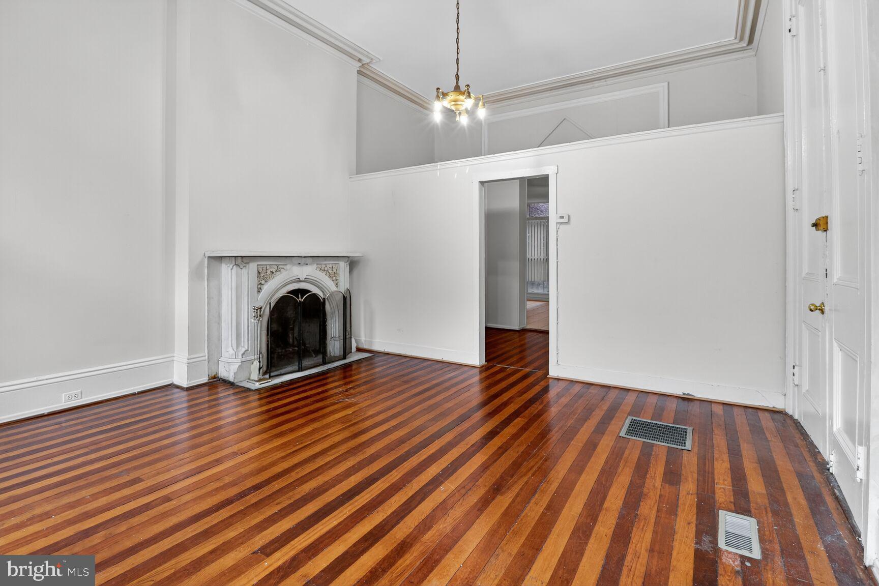 1404 Madison Avenue Baltimore, MD 21217 - Photo 4 of 54 a view of empty room with wooden floor and fireplace