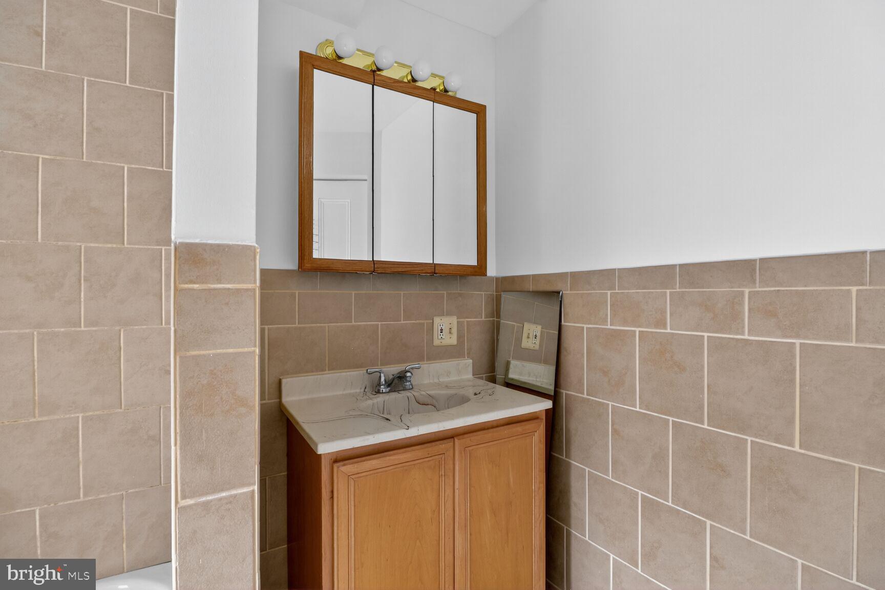 1404 Madison Avenue Baltimore, MD 21217 - Photo 47 of 54 a bathroom with a sink and a mirror