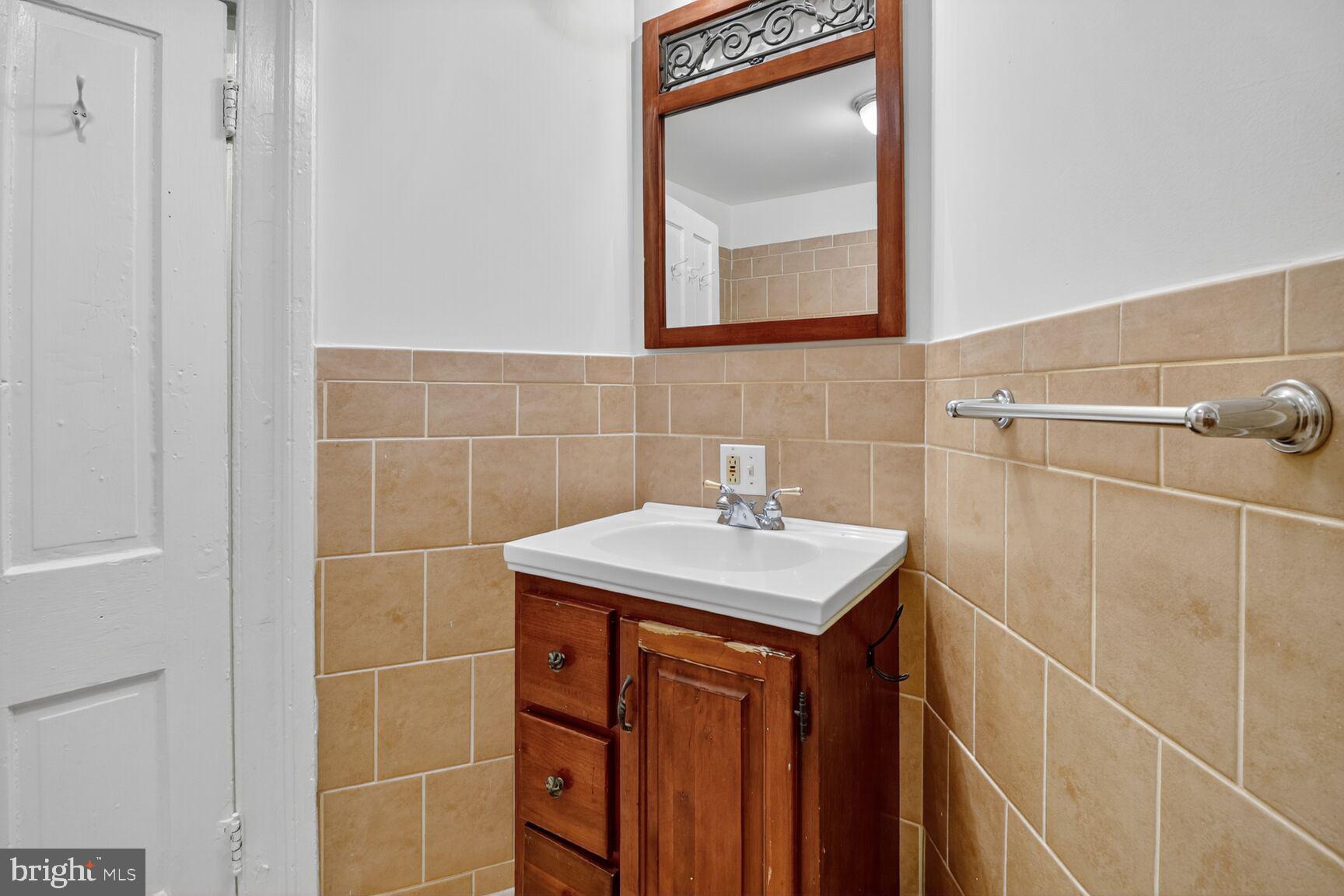 1404 Madison Avenue Baltimore, MD 21217 - Photo 48 of 54 a bathroom with a sink a toilet and a mirror