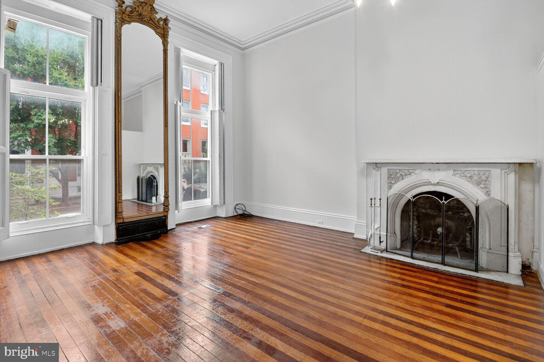 1404 Madison Avenue Baltimore, MD 21217 - Photo 5 of 54 an entryway with wooden floor a fireplace and a window