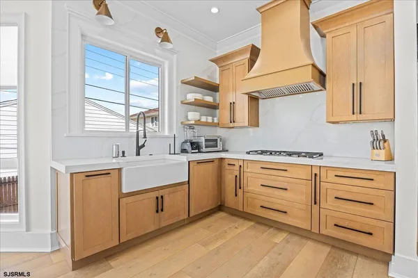 a open kitchen with stainless steel appliances granite countertop a refrigerator a oven a sink with wooden floors and cabinets