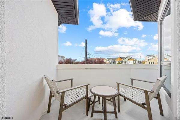 a view of an empty room with wooden floor and windows