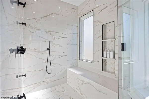 a large white bathroom with a tub sink and a mirror