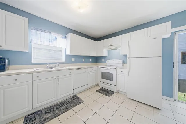 a kitchen with a cabinets a sink a window and stainless steel appliances