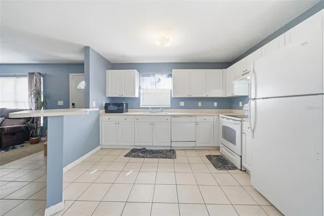 a kitchen with a white stove and white cabinets