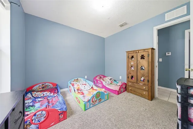 a backyard of a house with plants and large tree