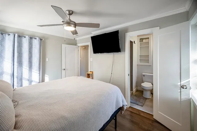 a bedroom with a large bed and a flat tv screen