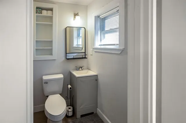 a bathroom with a toilet a sink and mirror