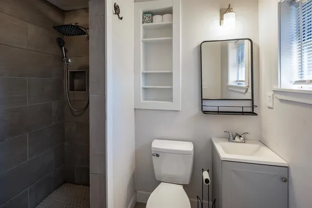 a bathroom with a toilet sink and mirror
