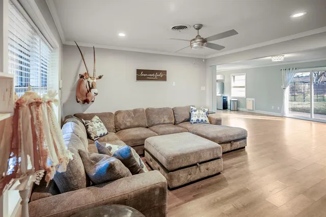 a living room with furniture and a ceiling fan