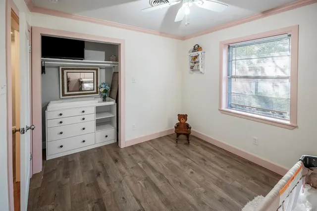 a view of an empty room with wooden floor and cabinet