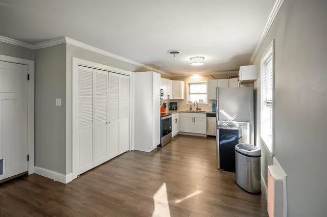 a kitchen with a sink a refrigerator and wooden floor
