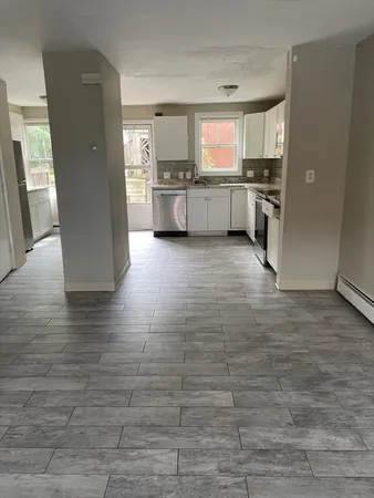 a large kitchen with cabinets and wooden floor