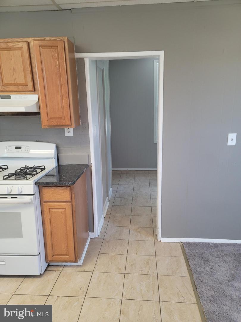 212 Rancocas Road Mount Holly, NJ 08060 - Photo 5 of 27 a kitchen with granite countertop a stove a sink and a refrigerator