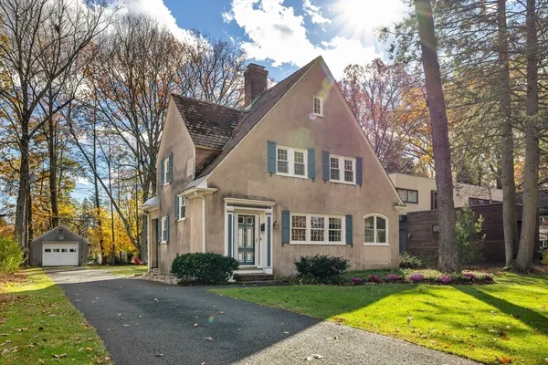 a view of a white house with a big yard and large trees