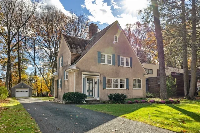 a view of a white house with a big yard and large trees