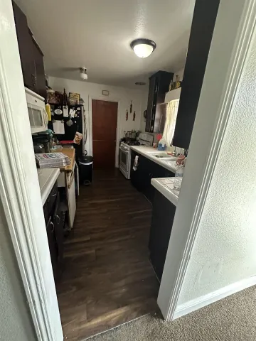 a view of a kitchen with sink and refrigerator