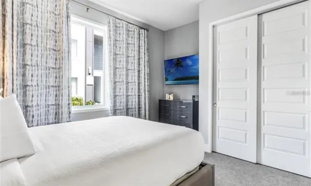 a bedroom with a bed and a large window