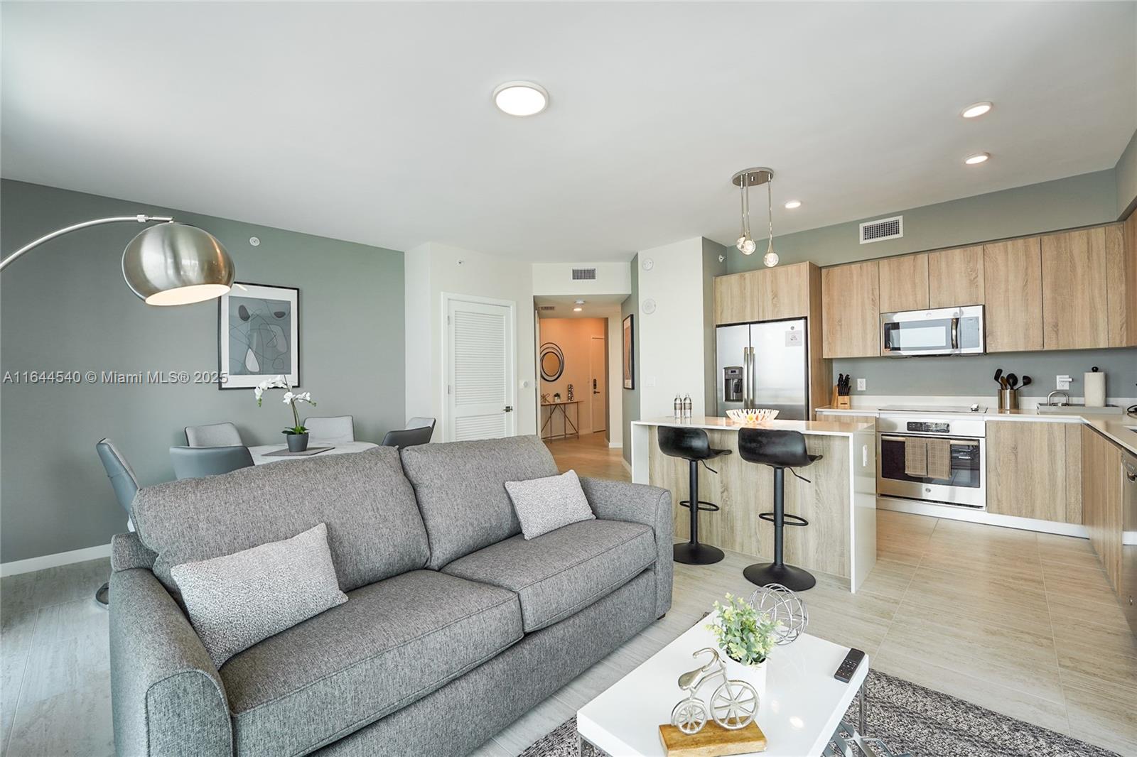 3900 Biscayne Boulevard, Unit S702 Miami, FL 33137 - Photo 4 of 12 a living room with furniture kitchen and a wooden floor