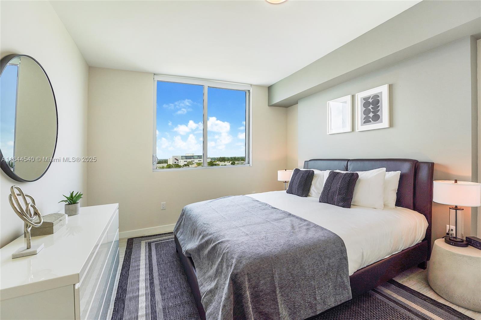 3900 Biscayne Boulevard, Unit S702 Miami, FL 33137 - Photo 6 of 12 a bed room with a bed mirror and a night stand