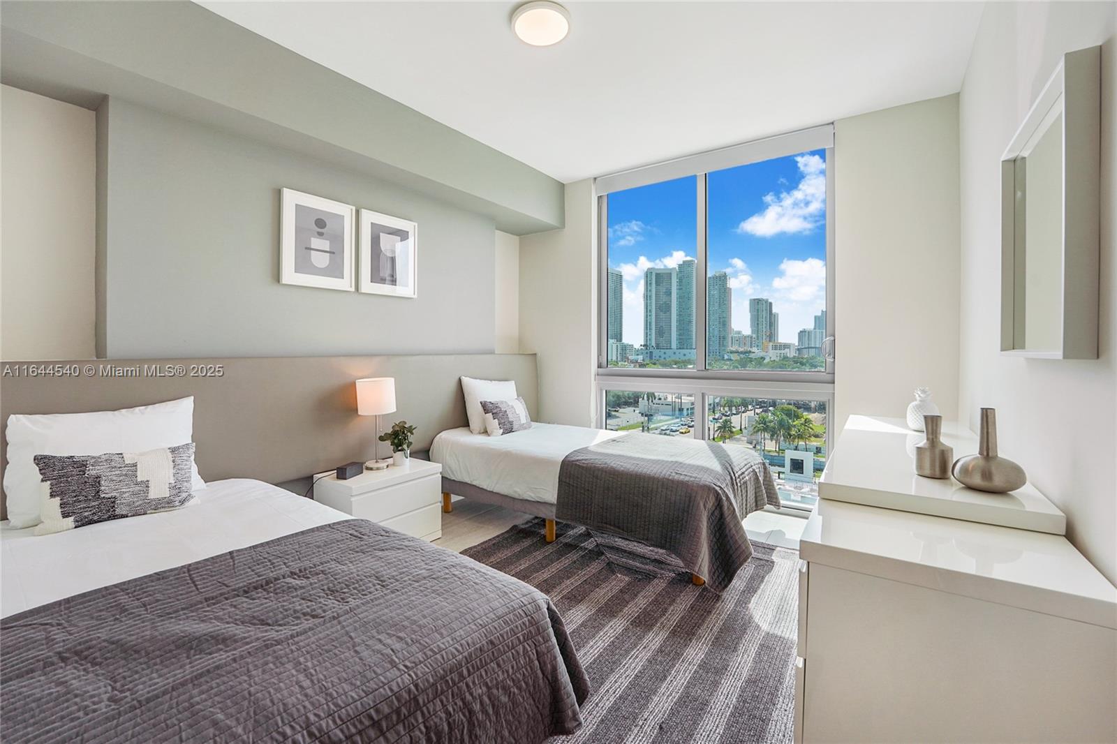 3900 Biscayne Boulevard, Unit S702 Miami, FL 33137 - Photo 7 of 12 a bedroom with two beds and a large window