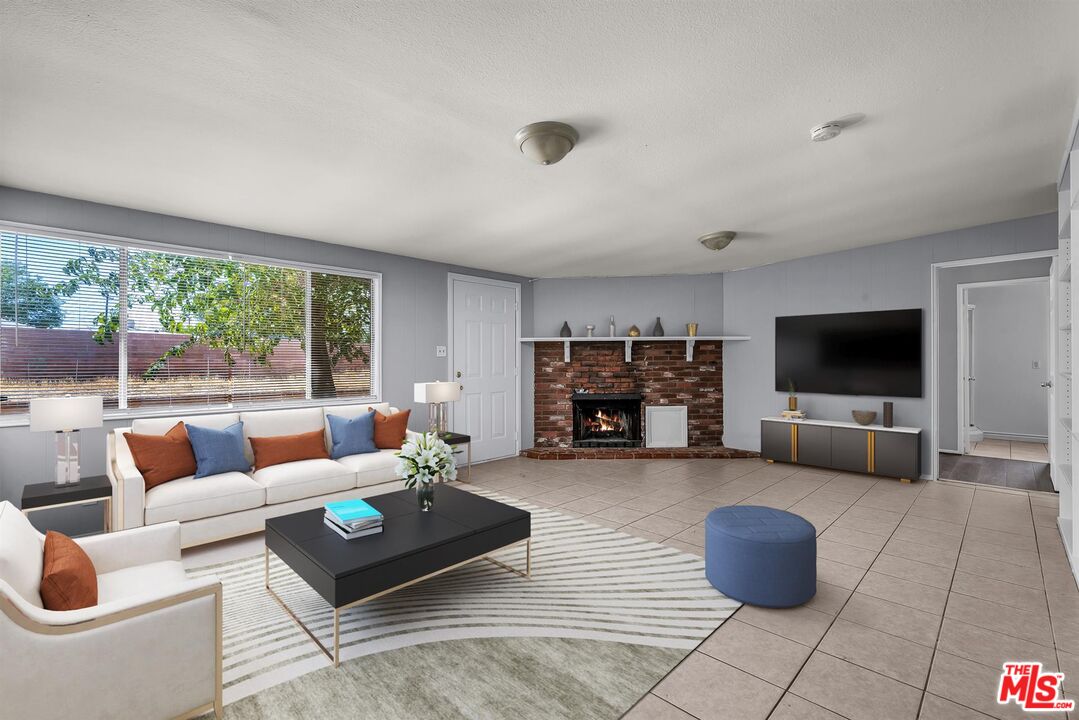 a living room with furniture a flat screen tv and a large window