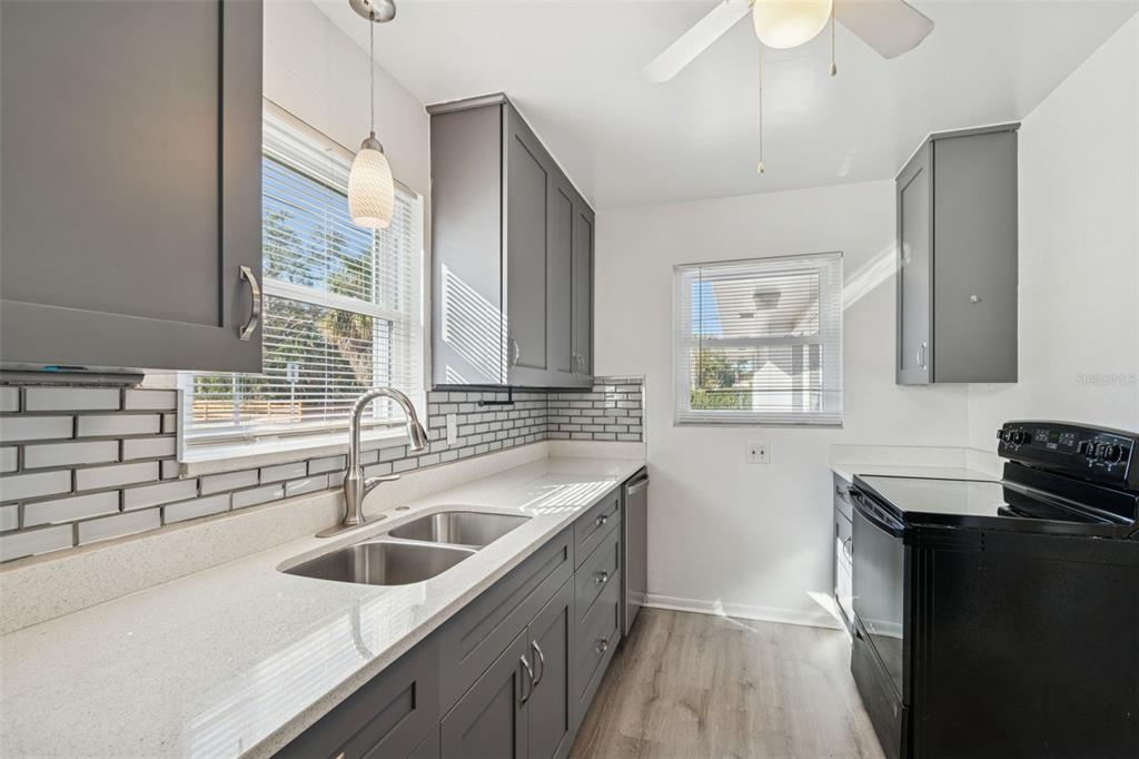 2900 49th Street North St. Petersburg, FL 33710 - Photo 12 of 52 a kitchen with a sink stove top oven and cabinets