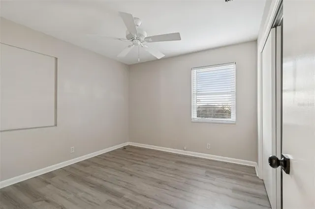 an empty room with fan and windows