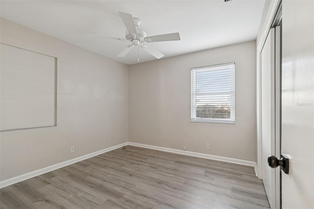 2900 49th Street North St. Petersburg, FL 33710 - Photo 31 of 52 an empty room with wooden floor fan and windows