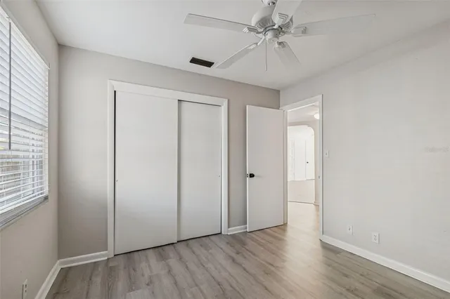 a view of a kitchen with white cabinets and wooden floor