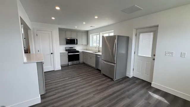 a kitchen with stainless steel appliances granite countertop a refrigerator and a stove top oven