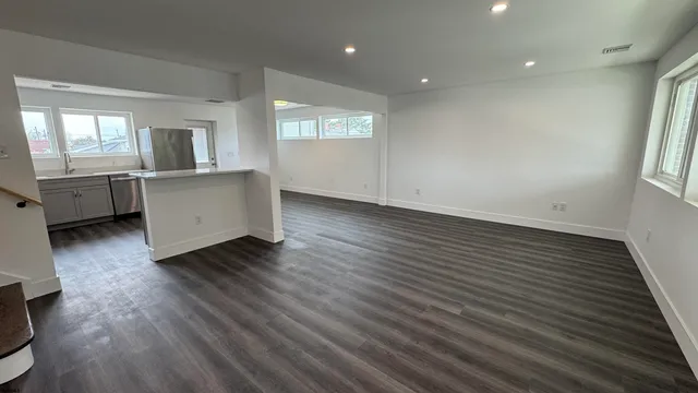 a view of a big room with wooden floor and windows