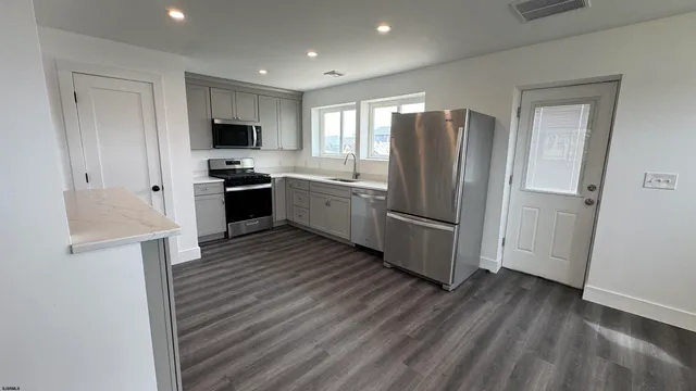 a kitchen with stainless steel appliances a refrigerator and a stove top oven