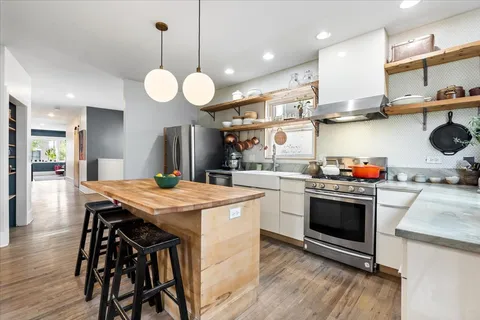 a kitchen with a sink counter top space and living room view